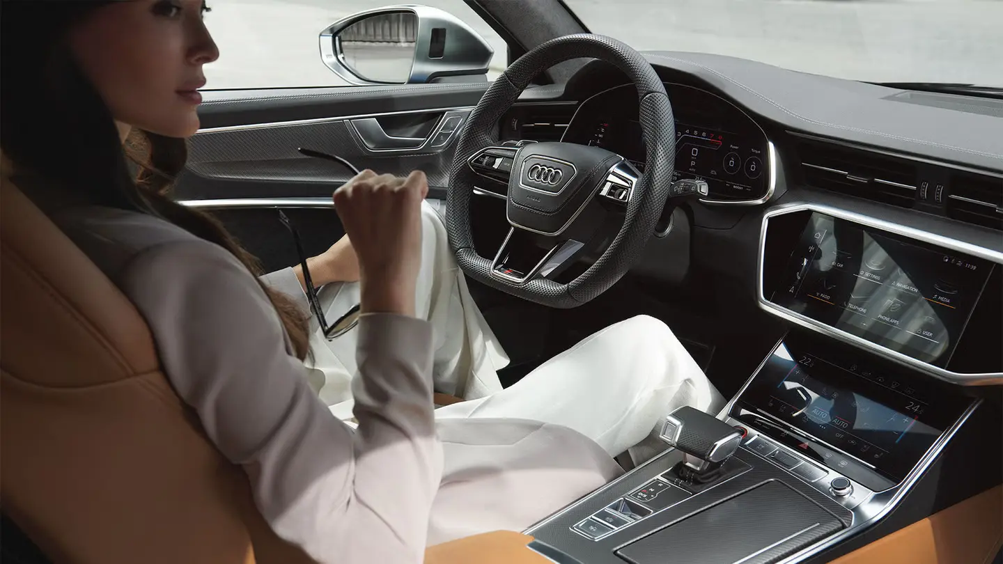 Mujer elegante al volante de un Audi de Alemania con interior tecnológico