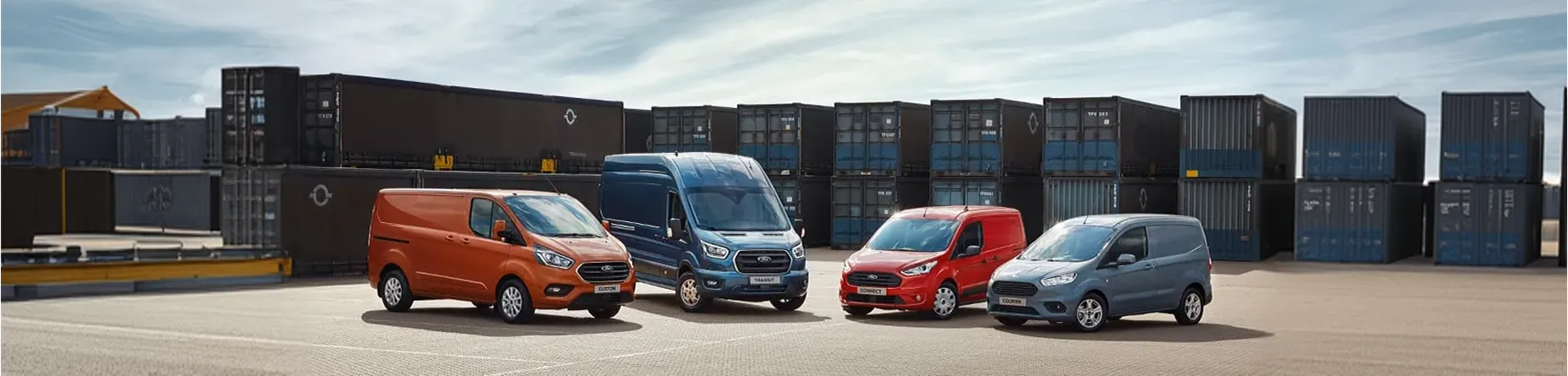 Furgonetas de importación de Alemania en exposición frente a contenedores logísticos